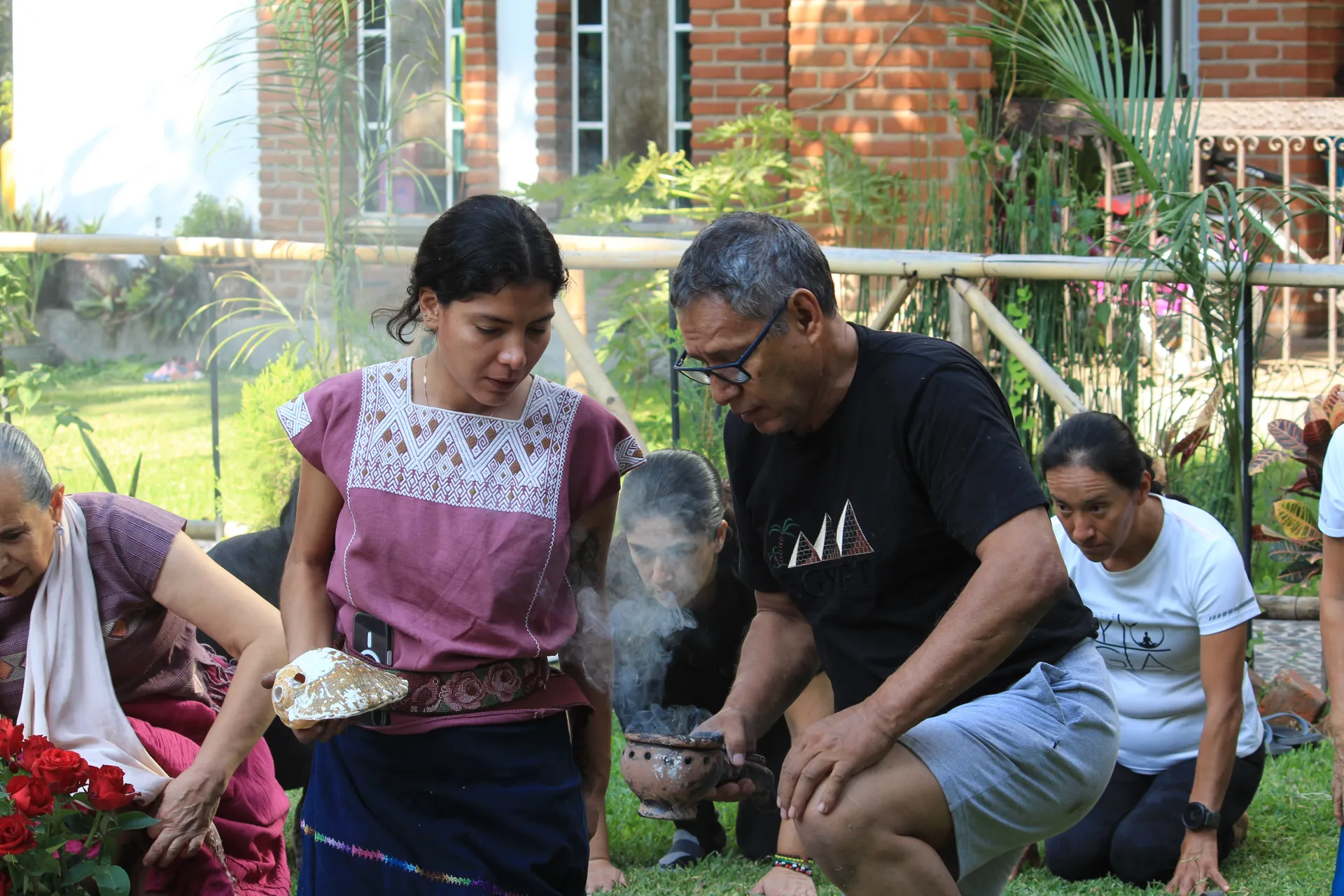 Grupo arrodillado alrededor del altar y el tambor