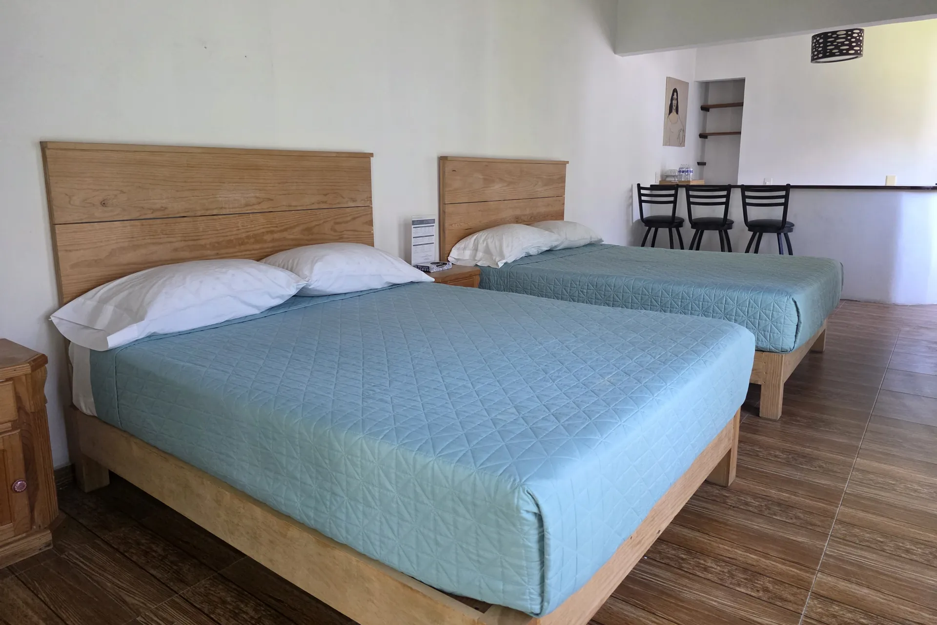 Habitación con dos camas de madera y colchas azul claro