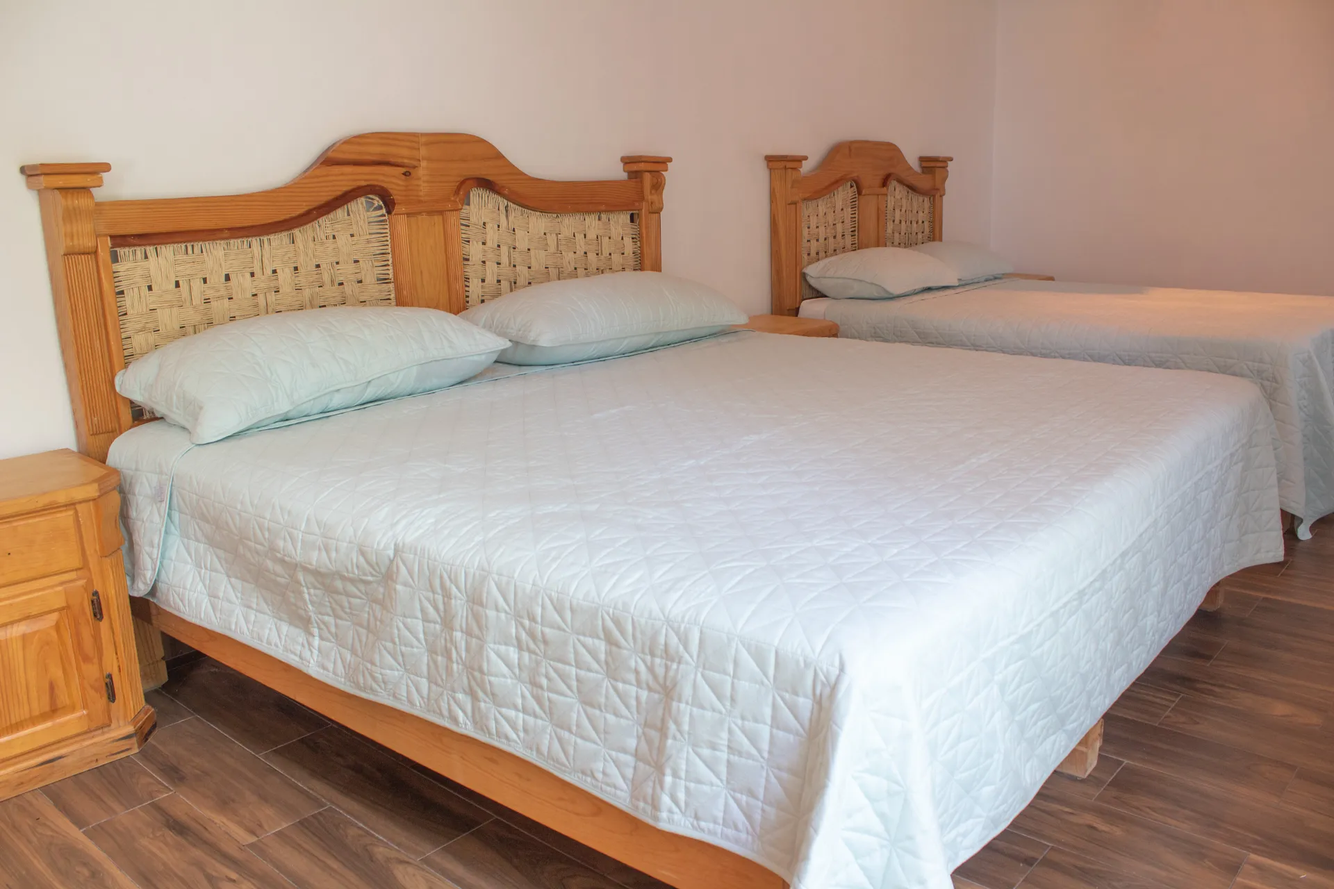 Habitación con camas de madera tallada y colchas azul claro
