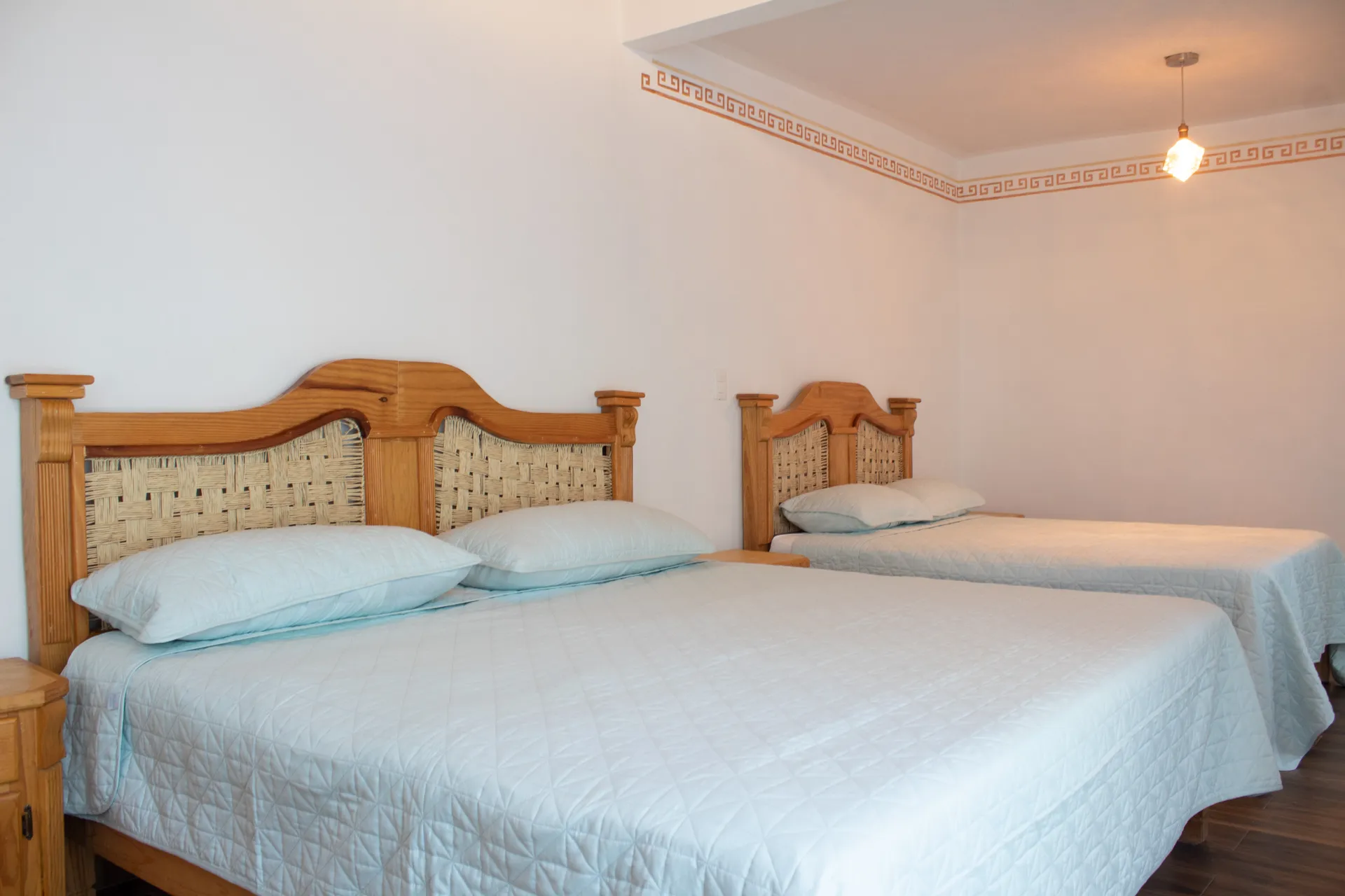 Habitación con camas de madera y colchas azul claro