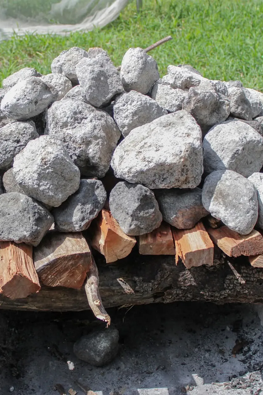 Piedras volcánicas sobre la leña, listas para calentarse